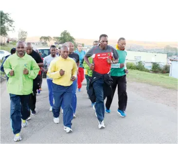  ??  ?? Grahamstow­n runners form a guard of honour for the hearse taking Eric Mapara to his family’s Tantyi home around 7am on Saturday 22 April 2017.