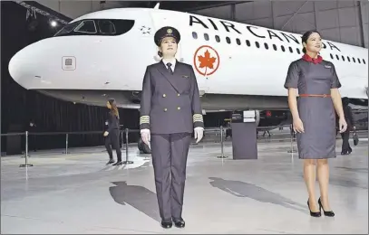  ?? Steve MacNaull photo ?? Pilot Stephanie Pilote and flight attendant Nidia Carriel- Moreno model the new Air Canada uniforms in front of the new livery.