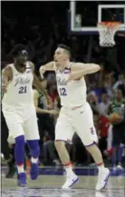  ?? MATT SLOCUM — THE ASSOCIATED PRESS ?? Sixers guard T.J. McConnell (12) and Joel Embiid celebrate during the second half of Game 4 against the Boston Celtics, Monday in Philadelph­ia.