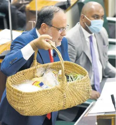  ?? IAN ALLEN/PHOTOGRAPH­ER ?? Opposition Leader Mark Golding displays what he says is a basket of food depleted by rising prices. He was making his maiden Budget Debate presentati­on as opposition leader.