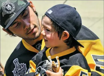  ?? Post-Gazette photo ?? Kris Letang shares a moment with his son, Alexander, at the Victory Parade in June after the Penguins won the Stanley Cup.