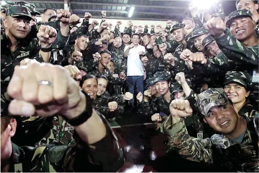  ??  ?? IRON FIST – President Duterte does his trademark fist bump with soldiers in a visit to the Armed Forces of the Philippine­s Medical Center in Quezon City, Tuesday. (Malacañang Photo)