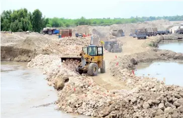  ??  ?? TOP: In Pakistan’s Sindh province, workers try to prevent the Indus from breaching itsbanks at Moria Loop Bund