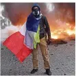  ?? FOTO: MATTIALE/DPA ?? Wieder gab es in Frankreich Gewalt und Zerstörung: Hier steht ein Demonstran­t in Paris vor einem brennenden Auto.