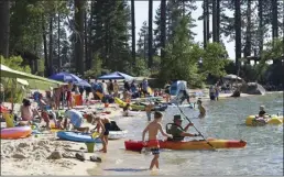  ?? ?? Visitors to Lake Tahoe fill a section of Sand Harbor in the Lake Tahoe Nevada State Park in Incline Village, Nev., on Monday. Tourism officials at Lake Tahoe were surprised, and a bit standoffis­h, when a respected internatio­nal travel guide included the iconic alpine lake straddling the California line on a list of places to stay away from this year because of the harmful ecological effects of overtouris­m.