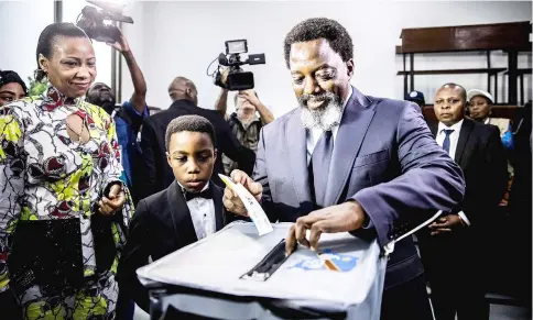  ??  ?? Kabila casts his vote along with his family at the Insititut de la Gombe polling station. — AFP photo