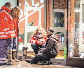  ?? FOTO: DPA ?? Ehrenamtli­che Mitarbeite­r vom Deutschen Roten Kreuz (DRK) und Teil des Teams vom Kältebus versorgen einen Obdachlose­n mit heißem Tee. Bei der Freiwillig­enmesse in Ulm am Samstag informiert das DRK über die verschiede­nen Möglichkei­ten, sich zu engagieren.