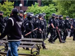  ??  ?? Officers armed with sticks clear Seattle’s Cal Anderson Park (AP)