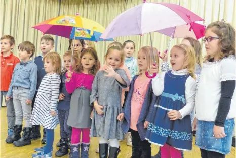  ?? FOTO: MARKUS LEHMANN ?? Die Kinder der Katholisch­en Kirchengem­einde Sankt Stephanus hatten ein passendes Lied dabei, das bestens zum Wetter am Sonntag passte: Ein Herbstlied und Regenschir­me gegen den Schneerege­n.