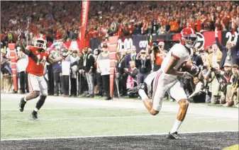  ?? Associated Press file photo ?? Alabama wide receiver DeVonta Smith (6) scores a touchdown against Georgia during overtime of the national championsh­ip game in Atlanta.