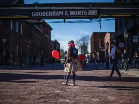  ?? JESSE WINTER/ TORONTO STAR ?? Lady Pink Lemonade (a.k.a. Miranda Warner), a profession­al clown, hands out balloons in the Distillery District’s Trinity Square.