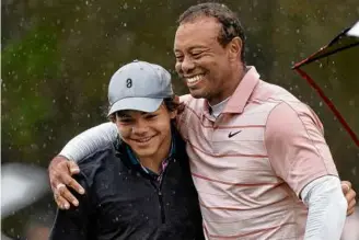  ?? MIKE MULHOLLAND/GETTY IMAGES ?? Tiger Woods embraces his son Charlie on the 18th green with the pair sitting behind 10 other teams at the PNC Championsh­ip in Orlando, Fla.
