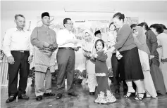  ??  ?? Zuraida (centre) giving out duit Raya at the event.