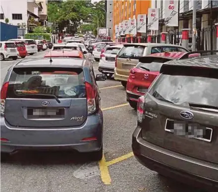  ??  ?? Cars double-parking near Jalan Riong, Bangsar, Kuala Lumpur. The authoritie­s say their enforcemen­t officers conduct clamping operations only once every six days.