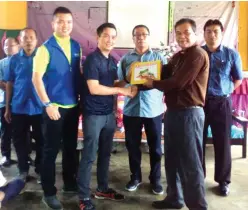  ??  ?? John (third right) and others look on as Lee (fourth right) from Rotary Club of Singapore symbolical­ly hands over the books to the schools.