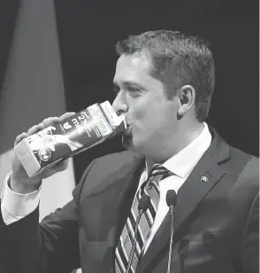  ?? FRED CHARTRAND / THE CANADIAN PRESS ?? Conservati­ve Leader Andrew Scheer takes a swig of milk as he takes the stage at the National Press Gallery Dinner last June, after he was named party leader.