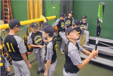  ?? GREG SORBER/JOURNAL ?? Eastdale’s Nico Barela looks over his bat before an indoor practice session at the Back2Back batting cages Monday. The players were chased inside because of rain.