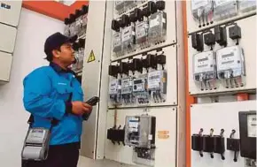  ?? FILE PIC ?? A TNB employee reading electricit­y meters in Bandar Baru Nilai, Negri Sembilan.