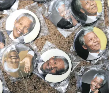  ?? PHOTO: BLOOMBERG ?? Hawkers sell “Mandela” badges. Nelson Mandela once said: “As long as poverty, injustice and gross inequality persists in this world, none of us can truly rest!”