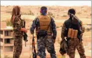  ?? SYRIAN DEMOCRATIC FORCES VIA AP ?? This April 30, 2017, file photo provided by the Syrian Democratic Forces (SDF) shows fighters from the SDF looking toward the northern town of Tabqa, Syria.