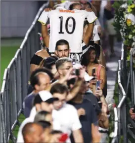  ?? CARLA CARNIEL / REUTERS ?? A mourner holds up a jersey on Jan 2 before passing the casket of Brazilian soccer legend Pele as he lies in state on the pitch of his former club Santos’ Vila Belmiro stadium in Santos, Brazil. After three days of national mourning, the country paid its final respects to the player known as “The King”, who died on Dec 29 at age 82 after a battle with cancer.