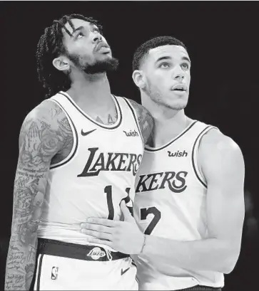  ?? Harry How Getty Images ?? BRANDON INGRAM is kept at bay by Lonzo Ball during Saturday’s home opener. Ingram was involved in a fight that led to a four-game suspension for him, three games for Rajon Rondo and two for Chris Paul.
