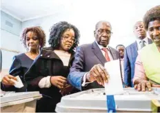  ?? — AFP ?? Former Zimbabwean president Robert Mugabe, his daughter Bona (C) and wife Grace cast their votes at a polling station in Harare.