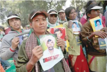  ?? — Reuters ?? Farmers from Telangana hold photograph­s of their relatives who, they claim, have committed suicide, during a rally organised by various farmers’ organisati­ons demanding complete debt waiver and good rates for their crops in New Delhi on Monday.