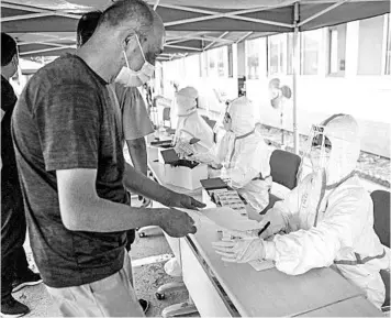  ?? GREG BAKER/GETTY-AFP ?? A man registers to undergo a swab test for the COVID-19 coronaviru­s Wednesday at a testing center in Beijing.