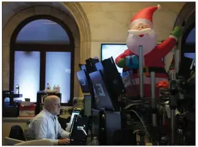  ?? (AP/Seth Wenig) ?? An inflatable Santa overlooks traders Monday on the floor at the New York Stock Exchange. Concerns about the economic effect of covid lockdowns in China helped push stocks lower Monday.