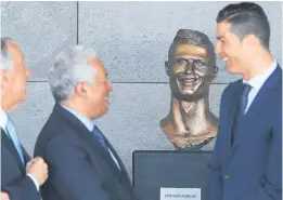  ?? Picture / AP ?? An odd bust of Portuguese football star Cristiano Ronaldo (right) is unveiled at a ceremony in his hometown of Funchal yesterday.