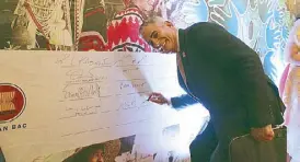  ??  ?? Jaime Augusto Zobel de Ayala signs the Hand-in-Hand Prosperity Mural depicting the collective efforts of private and public sectors and big brothers-small brothers to provide prosperity across the region.
