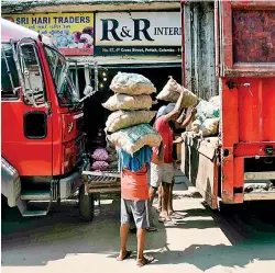  ?? ?? Lorry drivers who were loading goods from the Fort to be distribute­d in the provinces said hires have dropped and most shops in the provinces have closed. Pix by Akila Jayawarden­a
