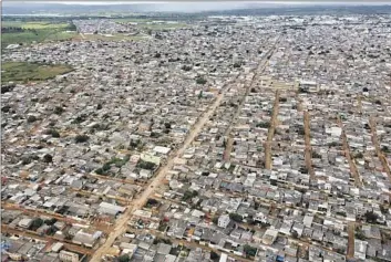  ?? Photograph­s by Eraldo Peres Associated Press ?? STREETS ARE FLOODED with rain March 22 in Sol Nascente, a low-income neighborho­od in Brasilia. Despite its challenges, a street vendor says, the favela is not as dangerous as Rio de Janeiro’s were in recent years.