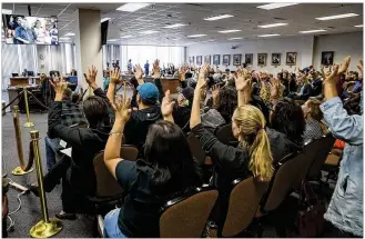  ?? RICARDO B. BRAZZIELL / AMERICAN-STATESMAN ?? Members of the audience wave their hands in support of citizen speakers to the Board of Education on Wednesday before a preliminar­y vote on creating a Mexican-American studies course for high school students in Texas. The course was approved on a 13-1...