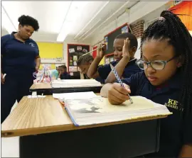  ?? THE ASSOCIATED PRESS ?? Elize’a Scott, a Key Elementary School third grade student, right, reads under the watchful eyes of teacher Crystal McKinnis, left, in Jackson, Miss. Mississipp­i and the District of Columbia showed gains on the Nation’s Report Card, along with some other big-city school districts.