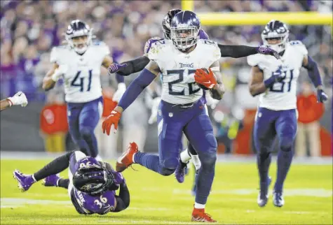  ?? Julio Cortez The Associated Press ?? Titans running back Derrick Henry rumbles past Ravens strong safety Chuck Clark in the second half of Tennessee’s 28-12 upset of the top seed in the AFC playoffs Saturday night in Baltimore. Henry finished with 195 yards rushing.