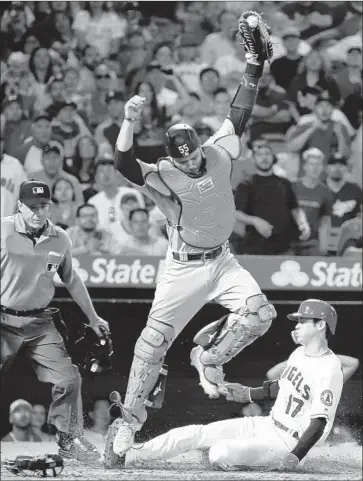  ?? Kent Nishimura Los Angeles Times ?? SHOHEI OHTANI scores a tiebreakin­g run for the Angels in the eighth inning as Dodgers catcher Russell Martin snags a high throw by third baseman Max Muncy and umpire Phil Cuzzi looks on.