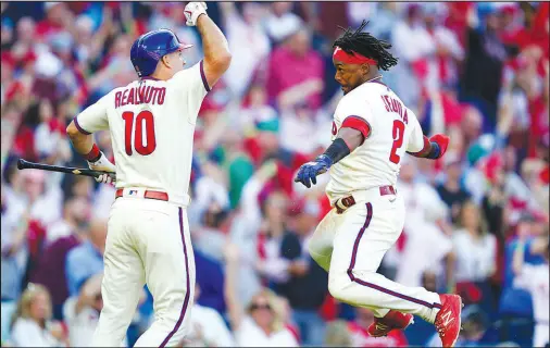  ?? Matt Rourke The Associated Press ?? Jean Segura celebrates with Phillies teammate J.T. Realmuto after scoring during the sixth inning of Philadelph­ia’s 8-3 victory over the Braves on Saturday at Citizens Bank Park. Realmuto hit an inside-the-park homer and an RBI single.