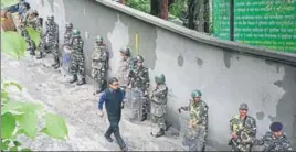  ?? AFP ?? Security personnel stand guard along a street as a man passes by in Darjeeling on Monday.