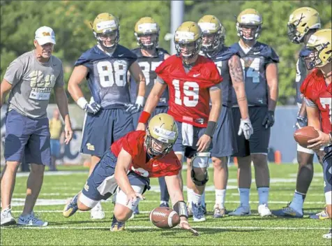  ??  ?? Quarterbac­k Kenny Pickett dives for a loose ball on the first day of camp at Pitt’s South Side practice facility.