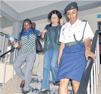  ??  ?? HELD: Yang Feng Glan, centre, who is suspected of traffickin­g ivory, is escorted by police officers as she leaves the Kisutu Residents Magistrate Court in Dar es Salaam, Tanzania, in October.