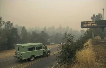  ?? Noah Berger/Associated Press ?? A fire transport drives along Highway 140, one of the entrances to Yosemite National Park, on Monday in Mariposa, Calif.