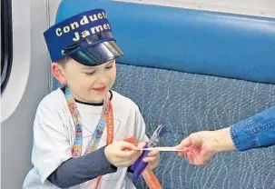  ?? KAYLA O’BRIEN/STAFF PHOTOGRAPH­ER ?? James Richart spent Friday greeting SunRail passengers and punching their tickets as an honorary conductor. His parents say the 4-year-old autistic boy is fascinated by trains and finds them soothing.