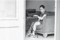  ?? Josie Norris / Staff photograph­er ?? Stephanie Mejia, 11, a student at SAISD’S Tafolla Middle School, sits on a couch at home as she looks at the day’s schoolwork.