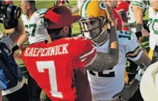  ??  ?? Colin Kaepernick and Green Bay’s Aaron Rodgers, who combined to throw for 745 yards and six touchdowns, exchange pleasantri­es after the 49ers’ victory.