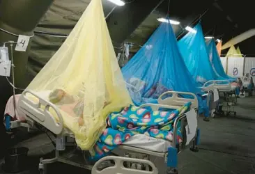  ?? MARTIN MEJIA/AP ?? Patients suffering from dengue lie in beds June 3 at the Health Ministry in Piura, Peru. The mosquito-borne disease is surging in the Western Hemisphere in numbers not seen since record-keeping began in 1980.