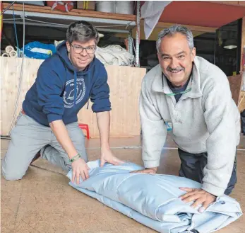  ?? FOTO: CORINNA KONZETT ?? Zusammenar­beit wird bei der Segelmache­rei Pfeiffer in Meersburg groß geschriebe­n. Marc (links) und Alf Pfeiffer legen ein fertiges Sonnensege­l zusammen.