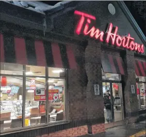  ?? CP PHOTO ?? A customer walks out of a Tim Hortons restaurant in Newcastle, Ont., in 2018.