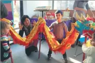  ??  ?? Children try out the dragon dance in London at a workshop during Spring Festival hosted by Oxford-based Snowflake Books.